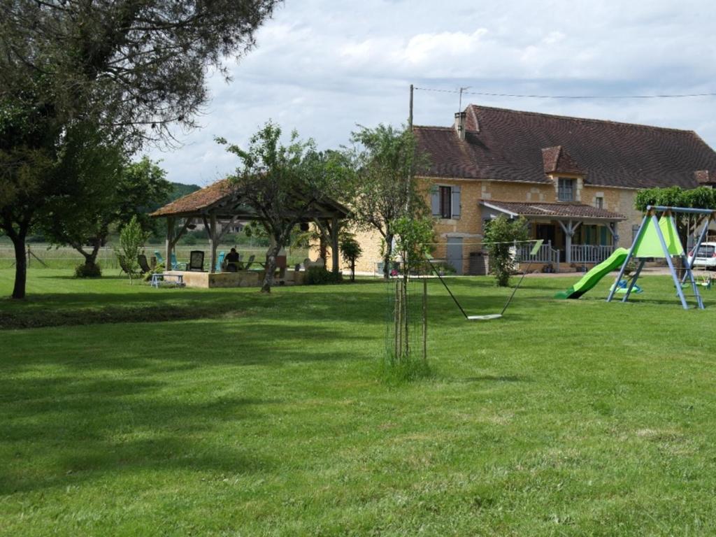 Maison en pierre avec grand jardin, proche Vézère, idéale pour familles et amateurs de pêche - FR-1-616-219 في Limeuil: ساحة مع ملعب أمام المنزل