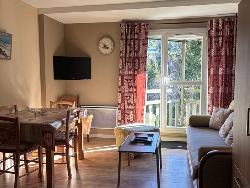un salon avec une table et une salle à manger dans l'établissement Charmant T2 avec Balcon Proche Ski - FR-1-787-127, à Laveissière