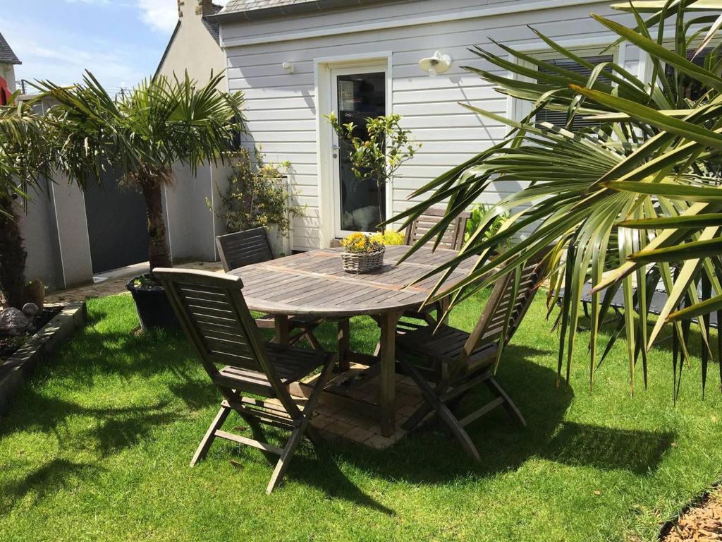 une table et des chaises en bois dans une cour dans l'établissement Maison élégante avec jardin et terrasse, WIFI au centre de Perros-Guirec - FR-1-368-455, à Perros-Guirec