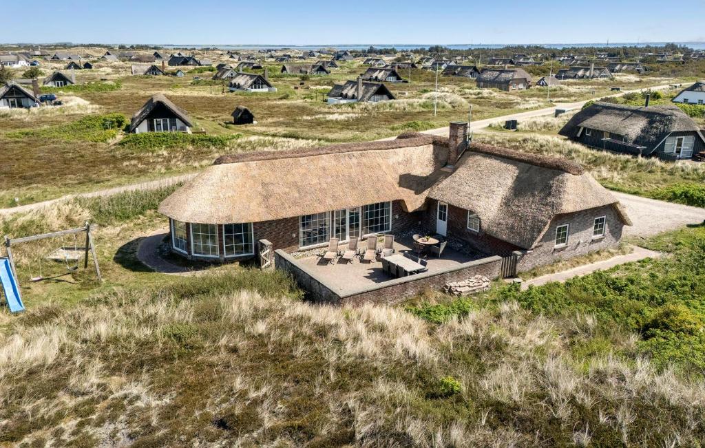 ein altes Haus mit einem Strohdach auf einem Feld in der Unterkunft Pet Friendly Home In Ringkøbing in Nørre Lyngvig