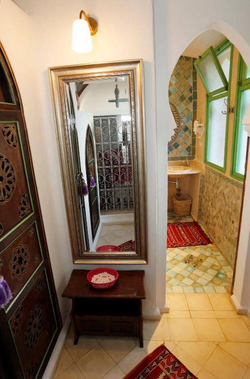 a bathroom with a large mirror on the wall at Riad Cherifa in Chefchaouene