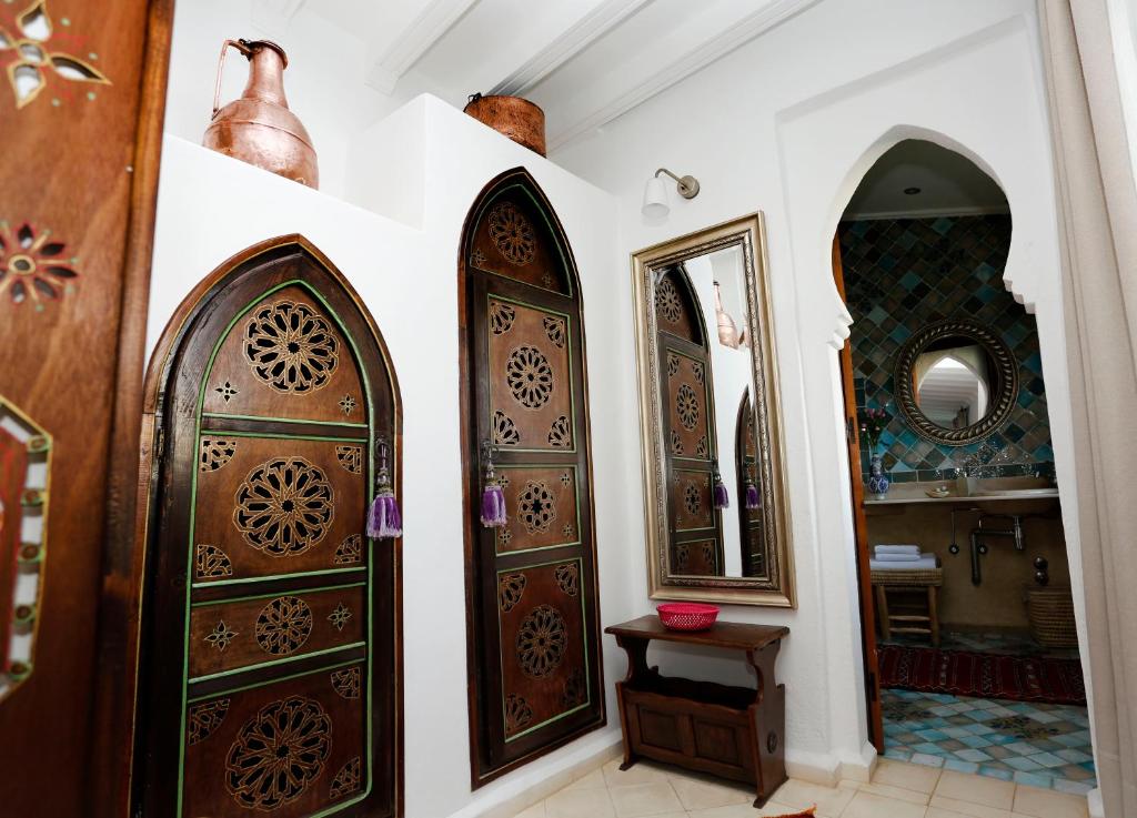 a hallway with two wooden doors and a mirror at Riad Cherifa in Chefchaouene