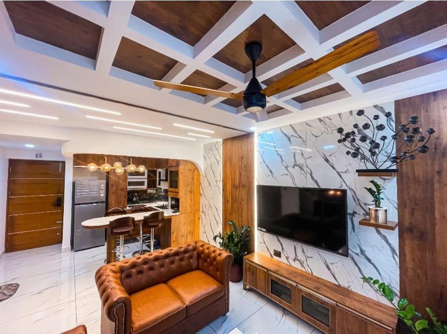 ein Wohnzimmer mit Sofa und Flachbildfernseher in der Unterkunft The Pink Luxe Apartment in Thiruvananthapuram