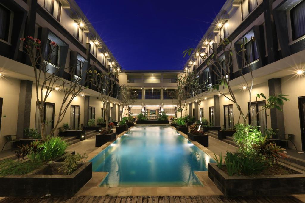 - une piscine au milieu d'un bâtiment la nuit dans l'établissement ILLIRA Lite Praya Lombok, à Praya