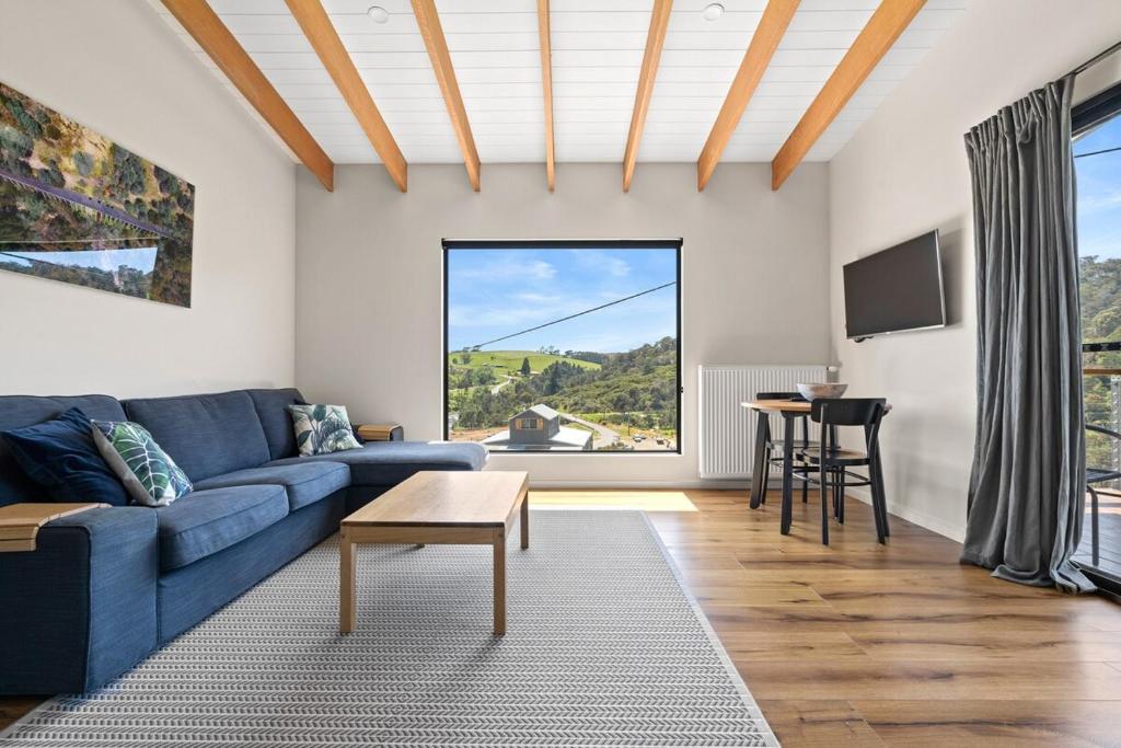 a living room with a blue couch and a table at The Derby Lodge 'One Bedroom' apartment retreat! in Derby