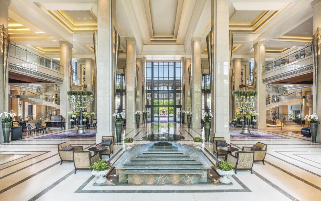 eine Lobby mit einem Brunnen in der Mitte eines Gebäudes in der Unterkunft Siam Kempinski Hotel Bangkok in Bangkok