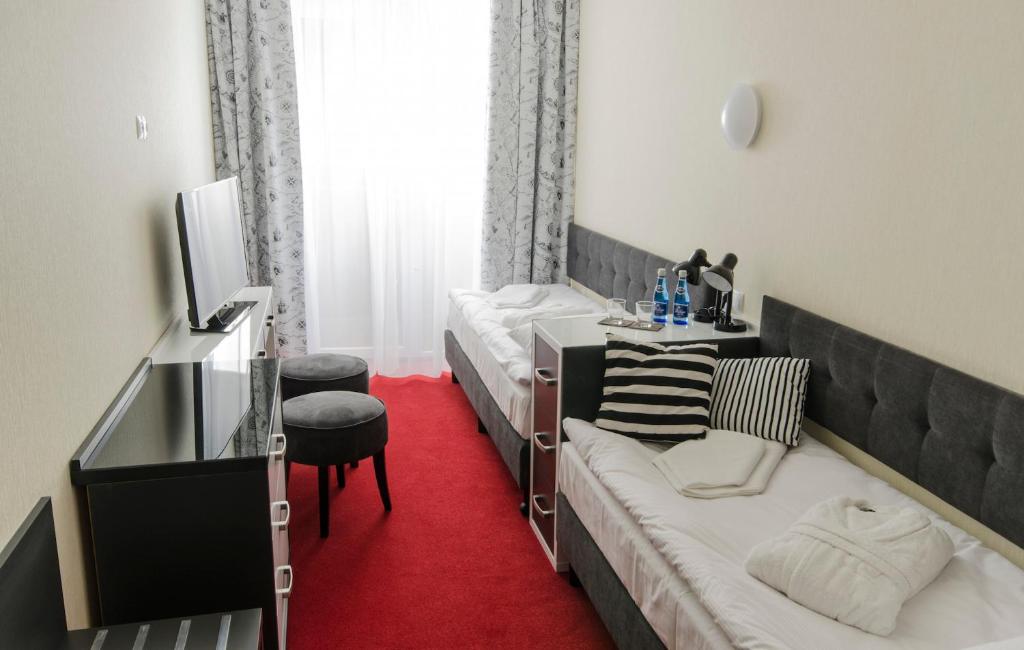 Łóżko lub łóżka w pokoju w obiekcie Grand Kapitan Medi Spa - POKOJE OZONOWANE