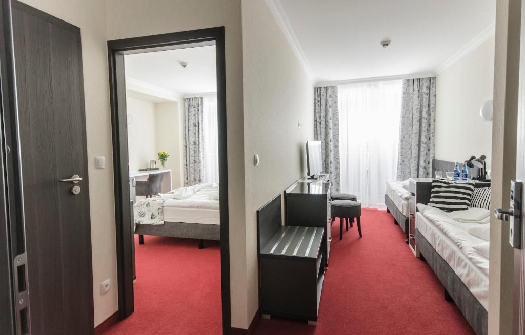 Łóżko lub łóżka w pokoju w obiekcie Grand Kapitan Medi Spa - POKOJE OZONOWANE
