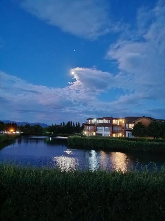 a view of a lake at night with a building at Atardecer en la Estepa in Dina Huapi