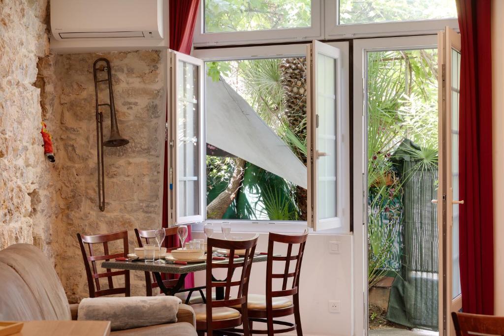 une salle à manger avec une table et des chaises et une fenêtre dans l'établissement À 1km Plage du Midi et Palais des Festivals - Appartement Centre Cannes avec Cour Extérieur Privée, à Cannes