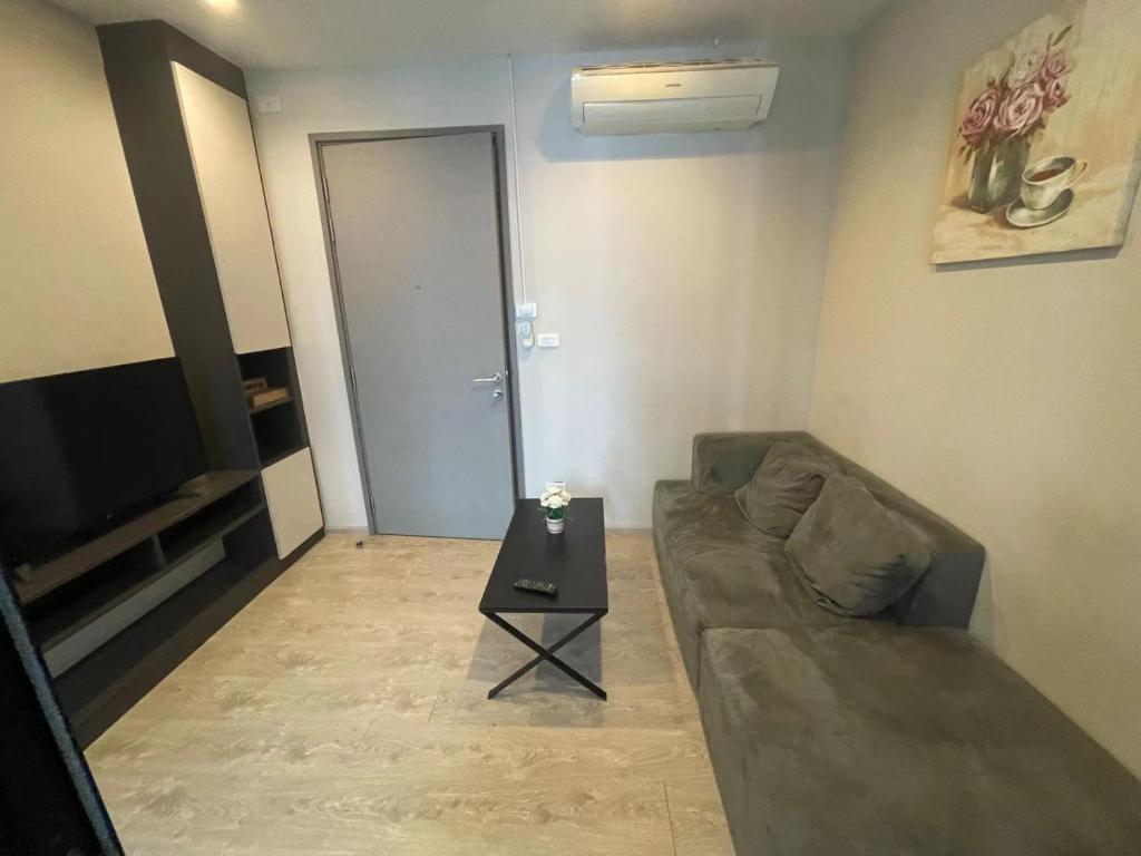 a living room with a couch and a table at 芭提雅市中心The Base 高端公寓酒店 in Pattaya