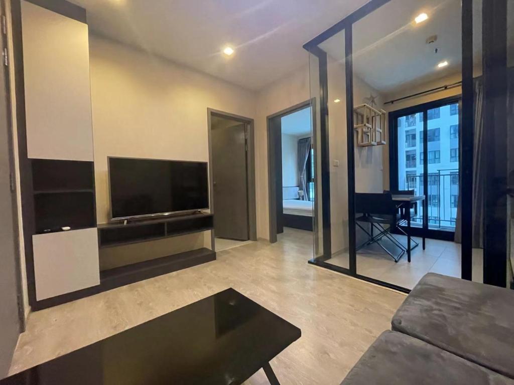 a living room with a couch and a television at 芭提雅市中心The Base 高端公寓酒店 in Pattaya