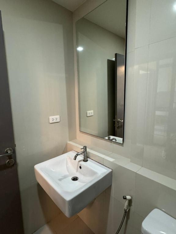 a bathroom with a sink and a mirror at 芭提雅市中心The Base 高端公寓酒店 in Pattaya
