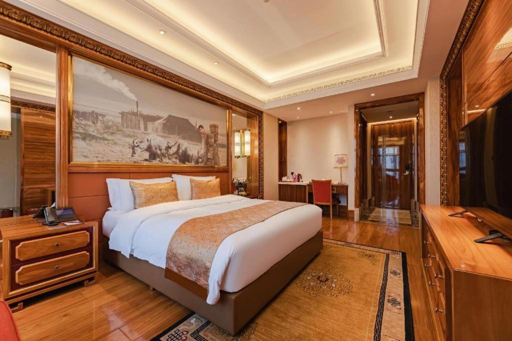 a large bedroom with a large bed and a desk at CHENGDU Trika Tsang International Hotel in Chengdu