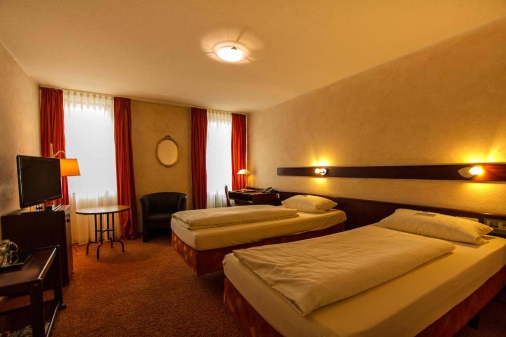 Postel nebo postele na pokoji v ubytování STADT-Hotel Lörrach GbR