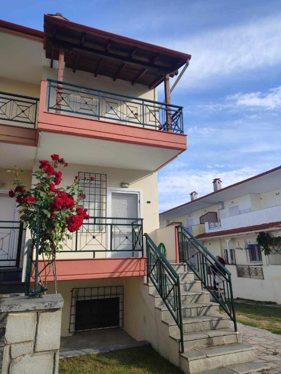 a building with stairs and a balcony with red flowers at Nicholas House in Siviri