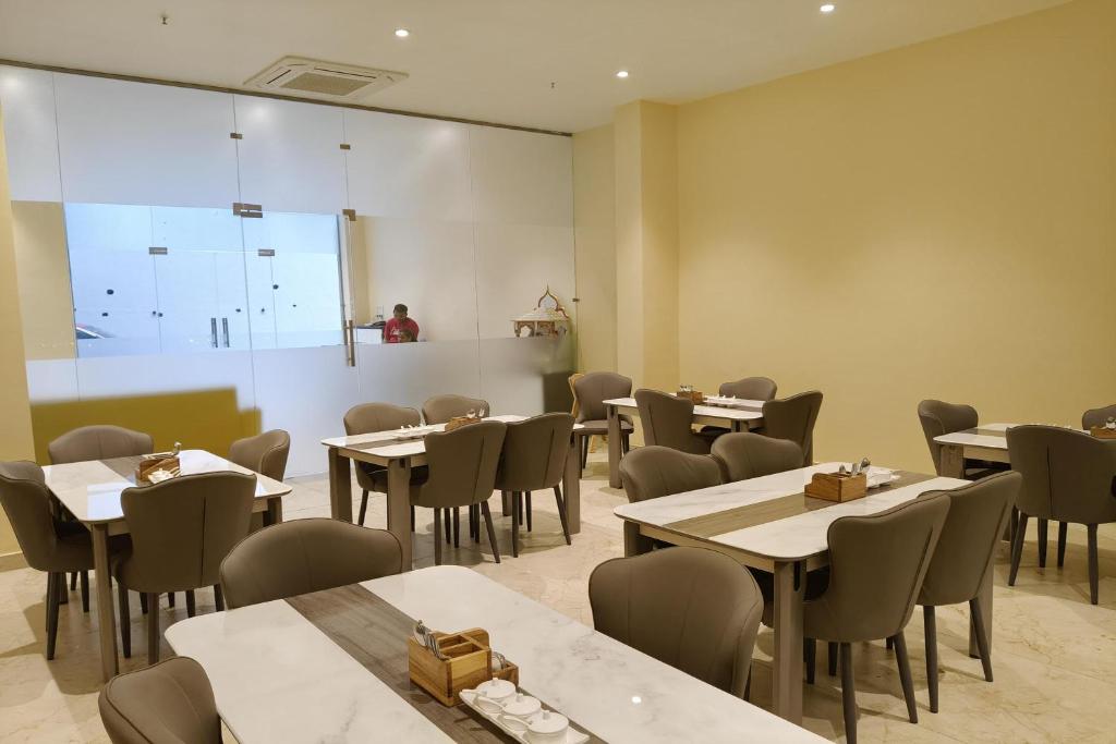 罗纳瓦拉The Vantage Point Resort & Spa的有桌椅和大窗户的餐厅