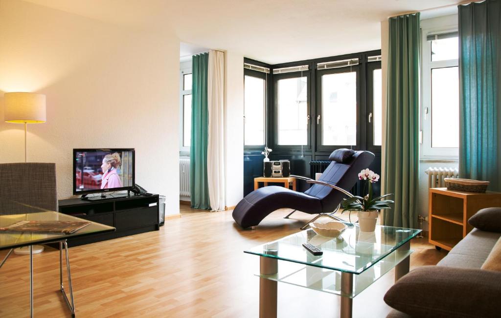 a living room with a chair and a television at STADT-Hotel Lörrach GbR in Lörrach