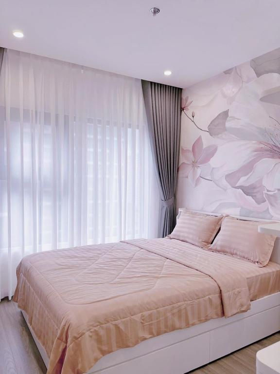 a bedroom with a large bed with a flower wall at Relax Homestay 6 in Kon Rung (1)