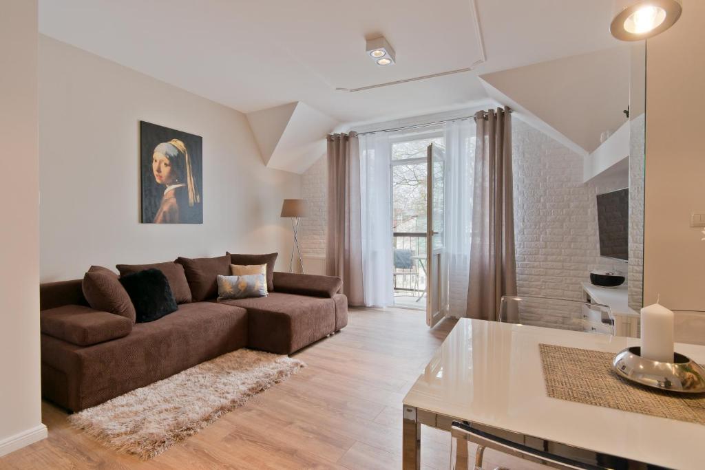 uma sala de estar com um sofá e uma mesa em Dream Apartments- Sopot Avenue em Sopot