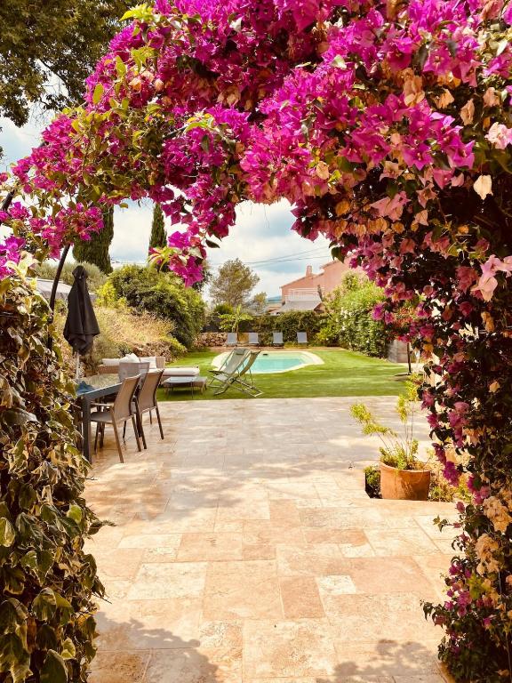 une arche avec des fleurs violettes dans un jardin dans l'établissement Villa 9 people maximum, à Bagnols-en-Forêt