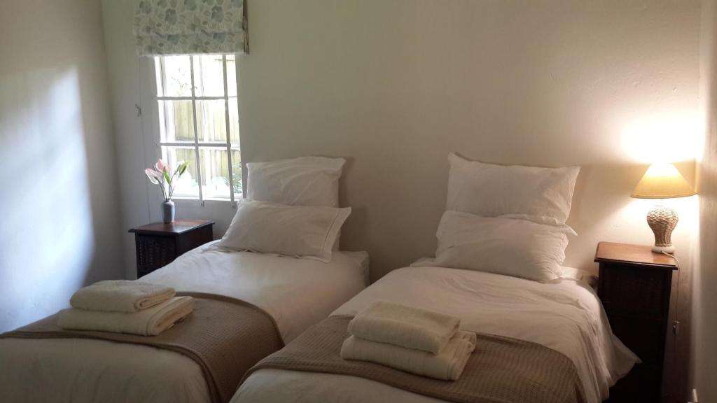 Duas camas num quarto com lençóis e almofadas brancos em Apartment Chapel Road em Hillcrest