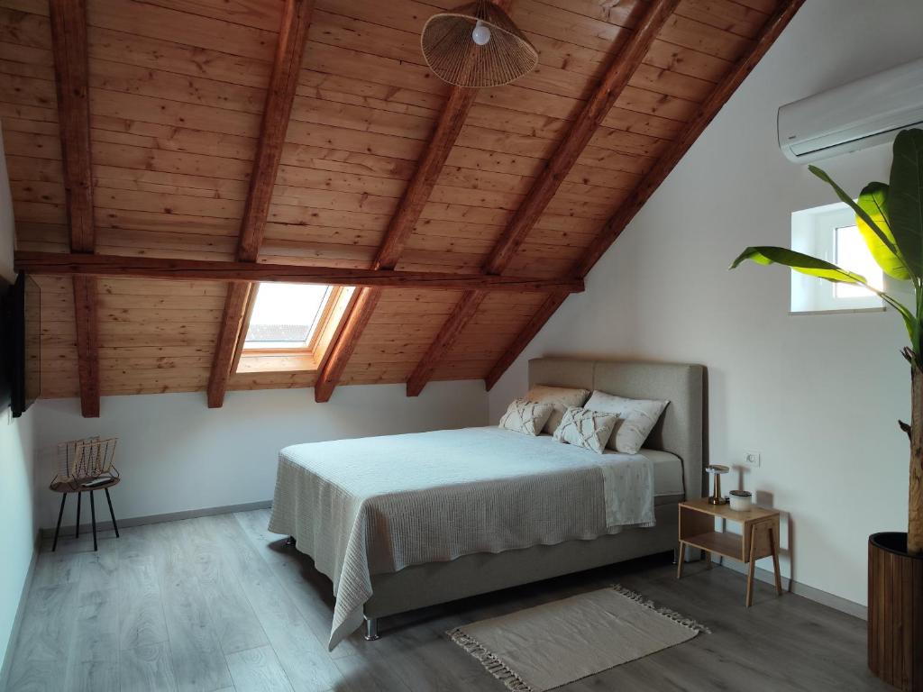 a bedroom with a bed and a wooden ceiling at Modern penthouse Ivan with rooftop swimming pool and jacuzzi in Drinovci