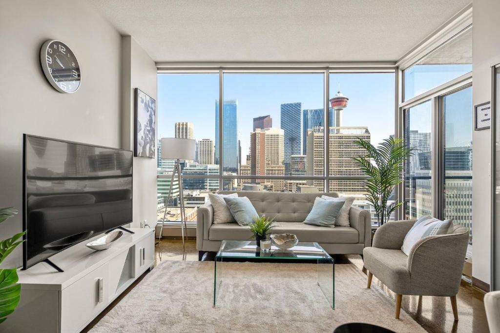 カルガリーにあるThe Prime Downtown | Luxe Condo + Free Parkingのソファとテレビのあるリビングルーム