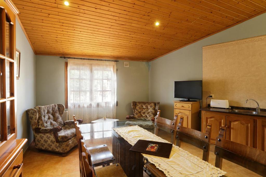 a living room with a table and chairs and a television at Apartaments Populetus in Poboleda