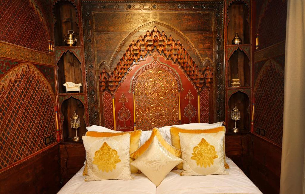 a bedroom with a bed with a wooden headboard at Riad Cherifa in Chefchaouene