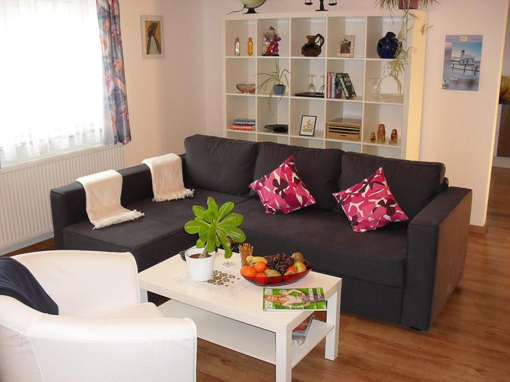 a living room with a black couch and a table at Ferienwohnung Ambrosia in Bad Birnbach