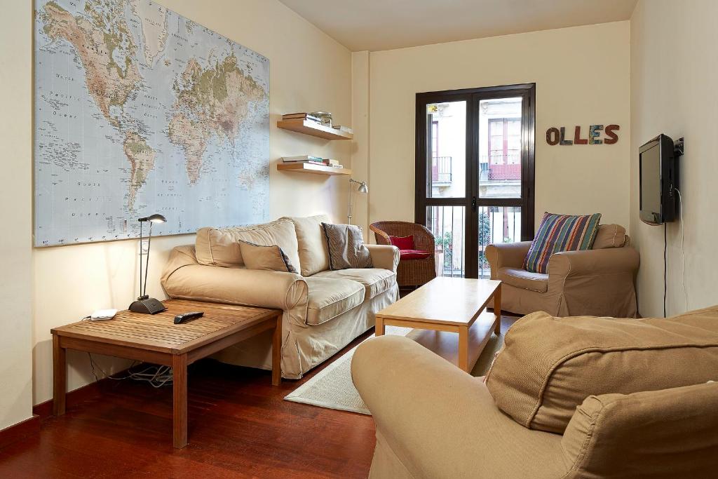 a living room with couches and a map on the wall at Olles Apartment in Barcelona