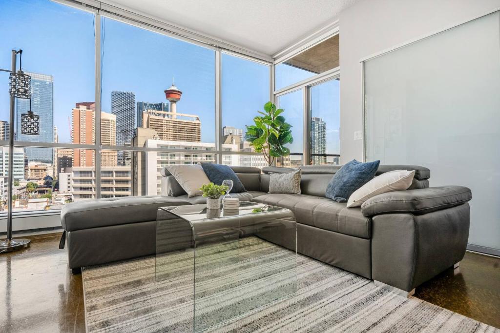 a living room with a couch and a large window at Downtown Chic Retreat | Elegant + Free Parking in Calgary