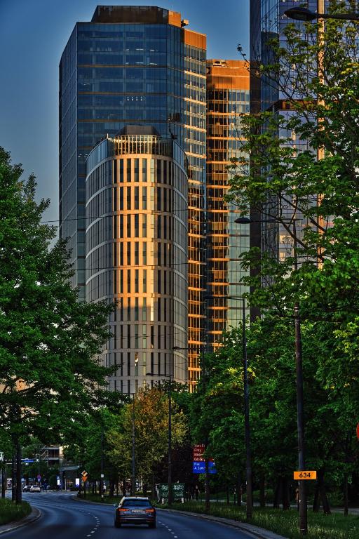 ワルシャワにあるCrowne Plaza - Warsaw - The HUB by IHGの高層ビルの前の道路を走る車