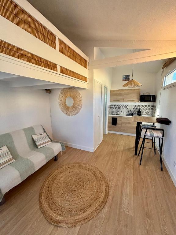 - un salon avec des lits superposés et un tapis dans l'établissement Studio Cosy à 200m de la plage, au Barcarès