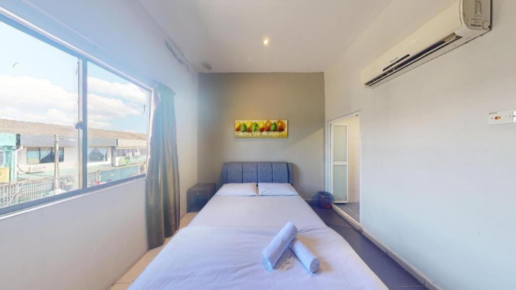 S Avenue Hotel في جوهور باهرو: غرفة نوم بها سرير ونافذة كبيرة