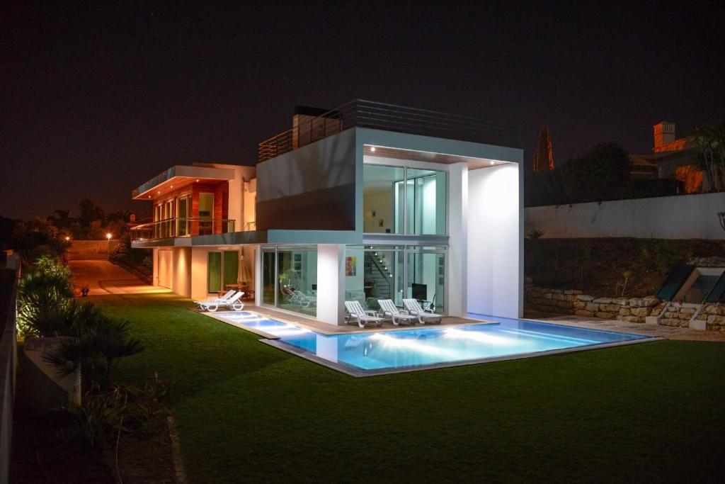 a house with a swimming pool at night at Palmares Beach, Golf & Dream in Lagos