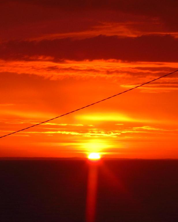 a sunset with the sun in the sky at An Creagán Rooms in Inisheer