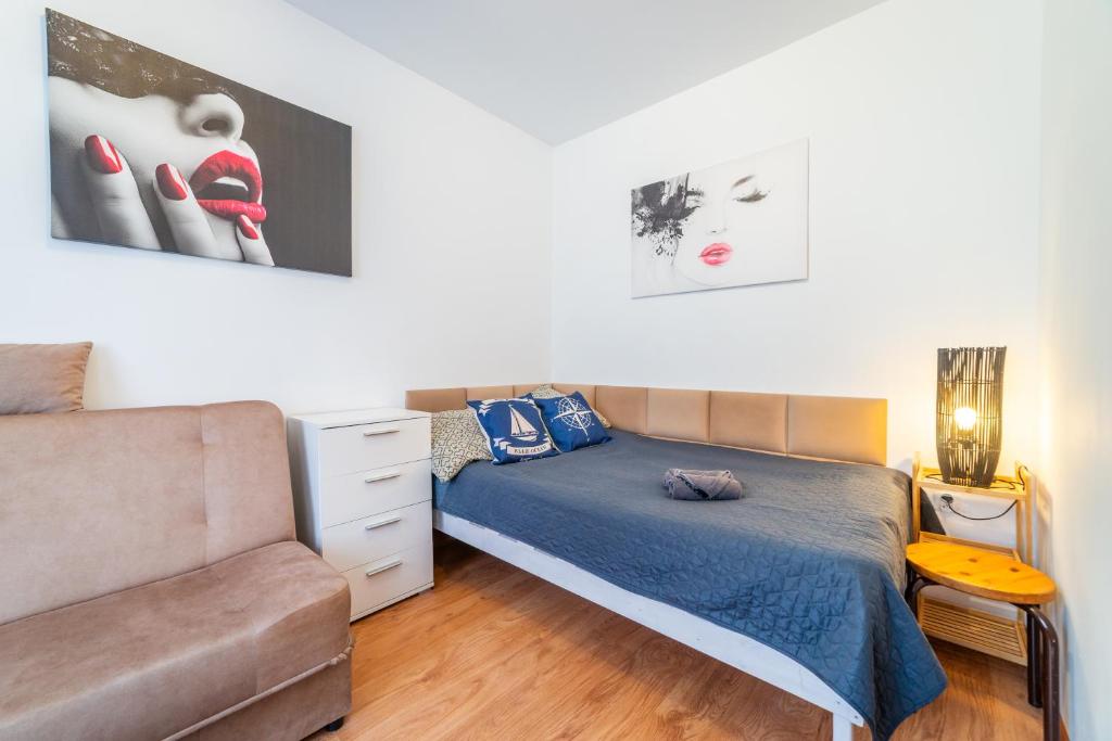 a bedroom with a bed and a couch at Pokój od strony ulicy Kajki, Mikołajki in Mikołajki