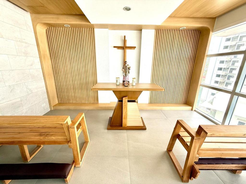 a church with benches and a cross on the wall at SkyLoft Cebu Casa Mira Guadalupe Aesthetic Japandi Loft with Balcony in Cebu City