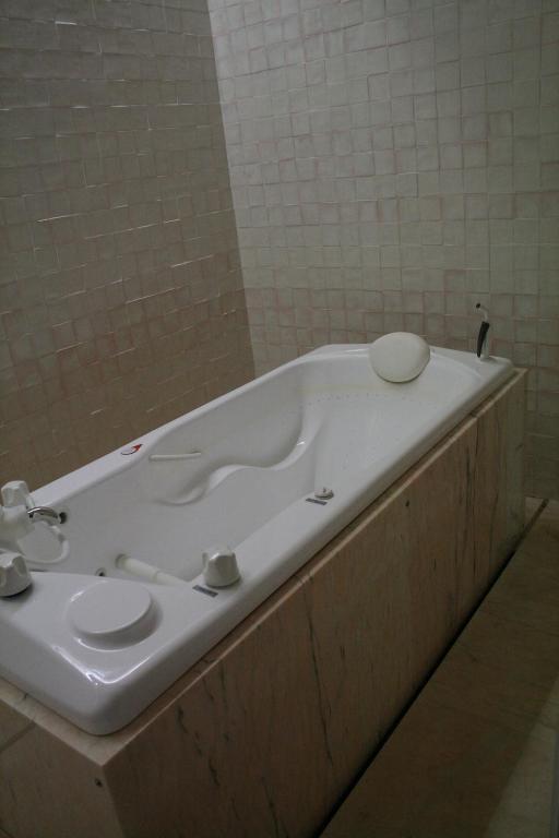 a bathroom with a bath tub with a sink at Hotel Porto Santo & Spa in Porto Santo
