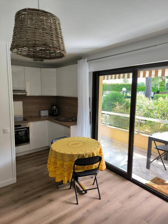 une cuisine avec une table et un chiffon de table jaune dans l'établissement Appart à deux pas de la plage Boulouris St Raphael, à Saint-Raphaël