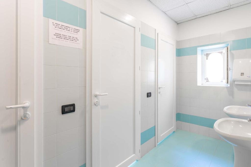 un bagno con lavandino e specchio di Ostello Bassano Del Grappa a Bassano del Grappa