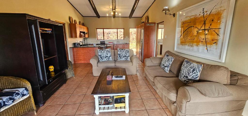 a living room with two couches and a coffee table at Robin Cottage Da Gama Lake in White River