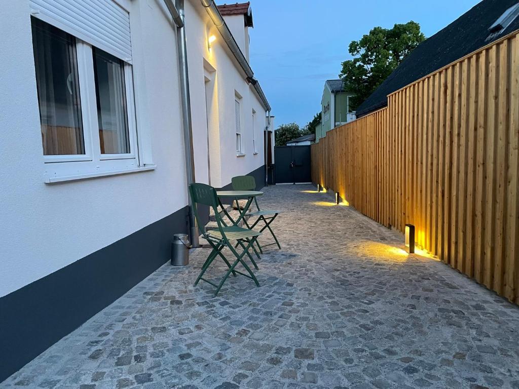 eine Terrasse mit 2 Stühlen und einem Tisch neben einem Gebäude in der Unterkunft HausKaiser in Wulkaprodersdorf