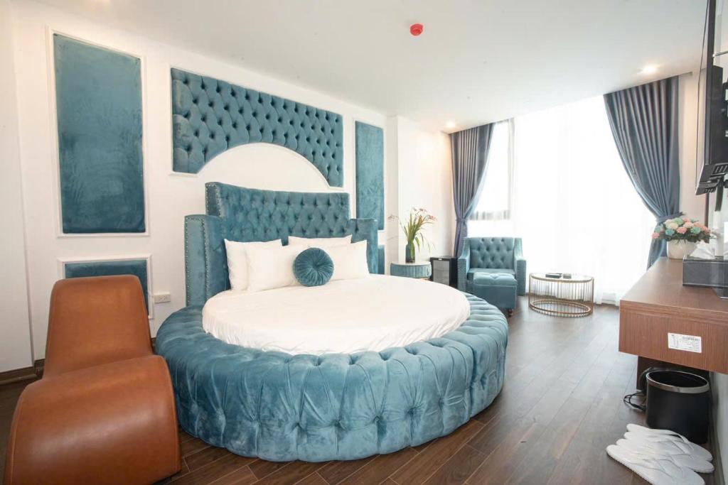a bedroom with a large blue bed and a chair at Royal Boutique Hotel in Ða Phúc