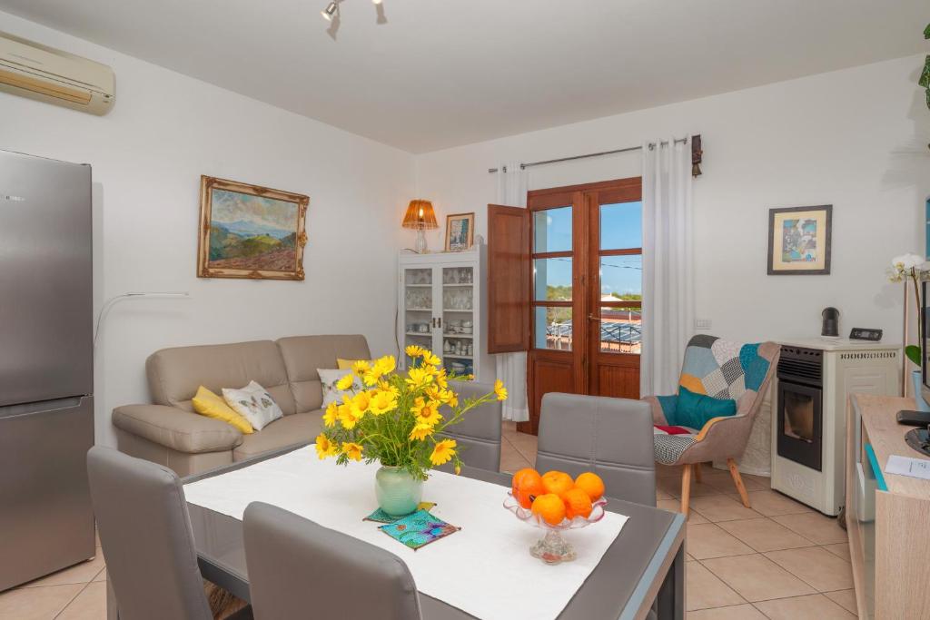 Una cocina y una sala de estar con una mesa con flores. en Appartamento Mountain View, en San Pantaleo
