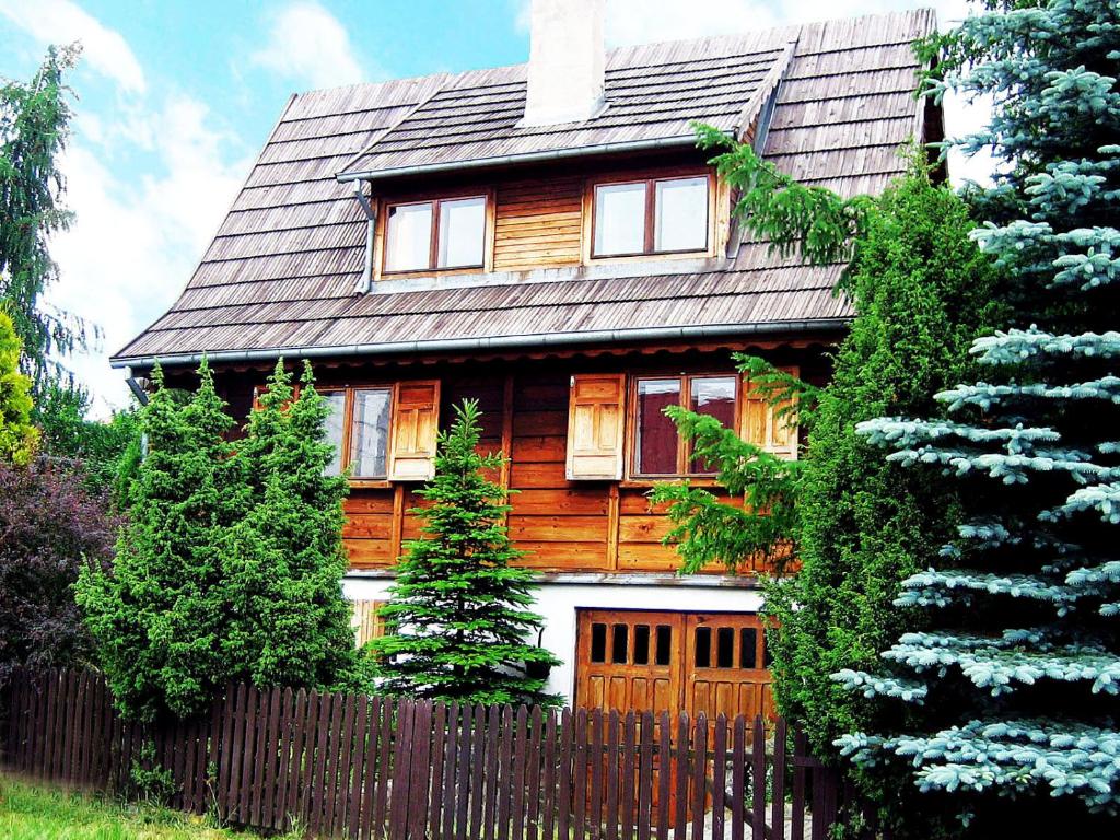a wooden house with a fence in front of it at Dom z Bali Paweł nad jeziorem Tajty in Giżycko