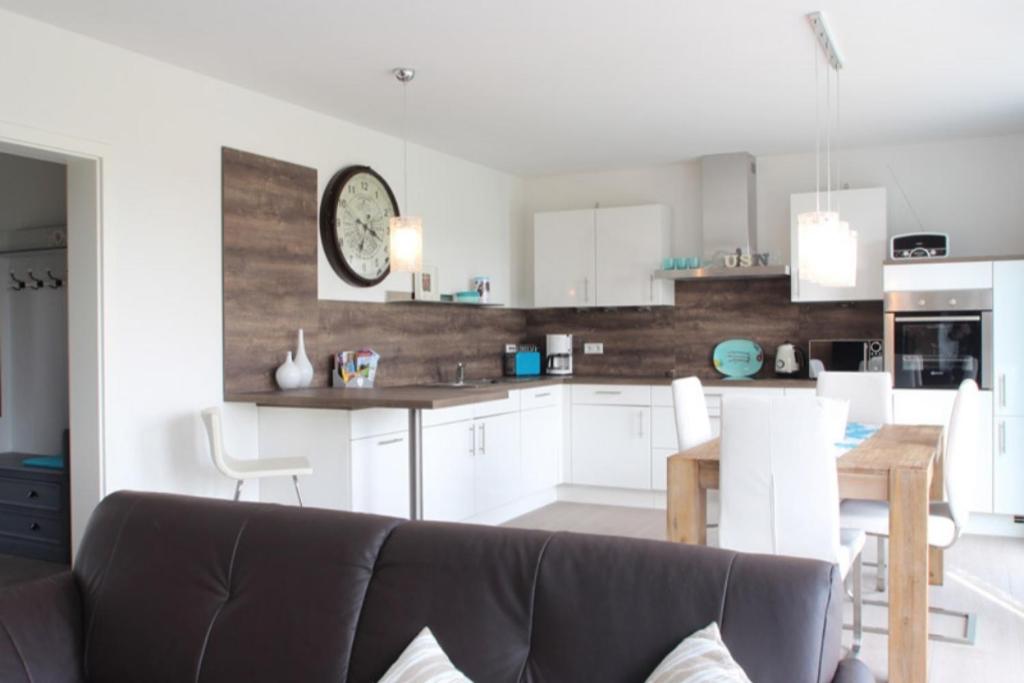 a kitchen and dining room with a couch and a table at Maison du Bonheur in Rerik