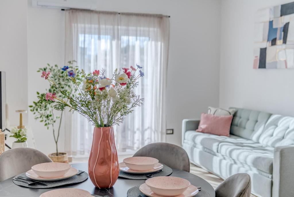 a dining room table with a vase of flowers on it at Apartman Sea in Podstrana